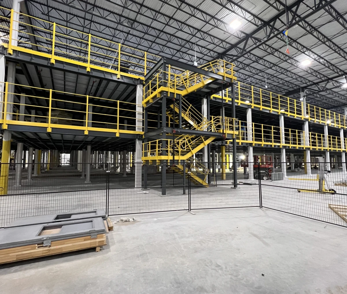 Industrial warehouse under construction with yellow railings.